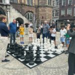 Kampioen van Nederland Max Warmerdam schaakt op de Markt in Venlo tegen een groepje jeugdspelers. (foto Frank Clevers)